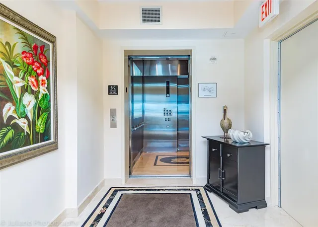 a dining room with furniture a chandelier and a large window