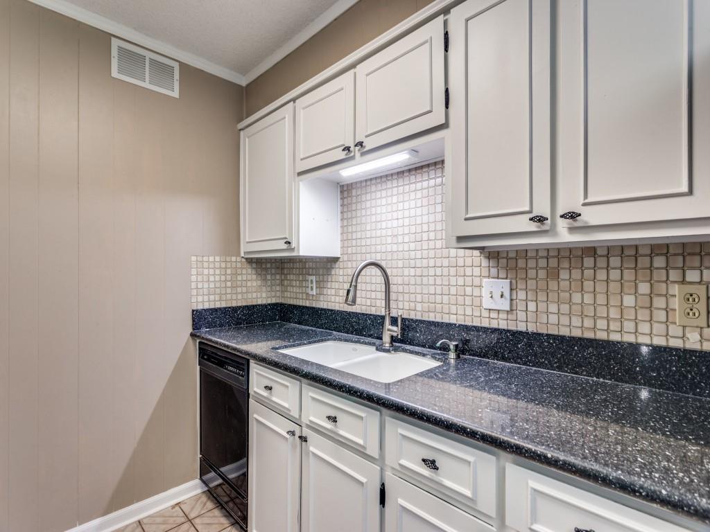 1216 Manning Street Benbrook, TX 76126 - Photo 9 of 26 Kitchen with decorative backsplash, black dishwasher, white cabinets, crown molding, and dark stone counters