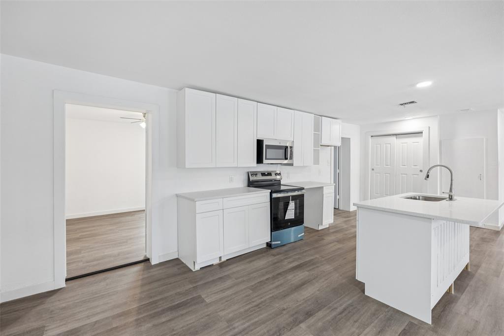 3847 Stalcup Road Fort Worth, TX 76119 - Photo 12 of 30 a kitchen with white cabinets and stainless steel appliances