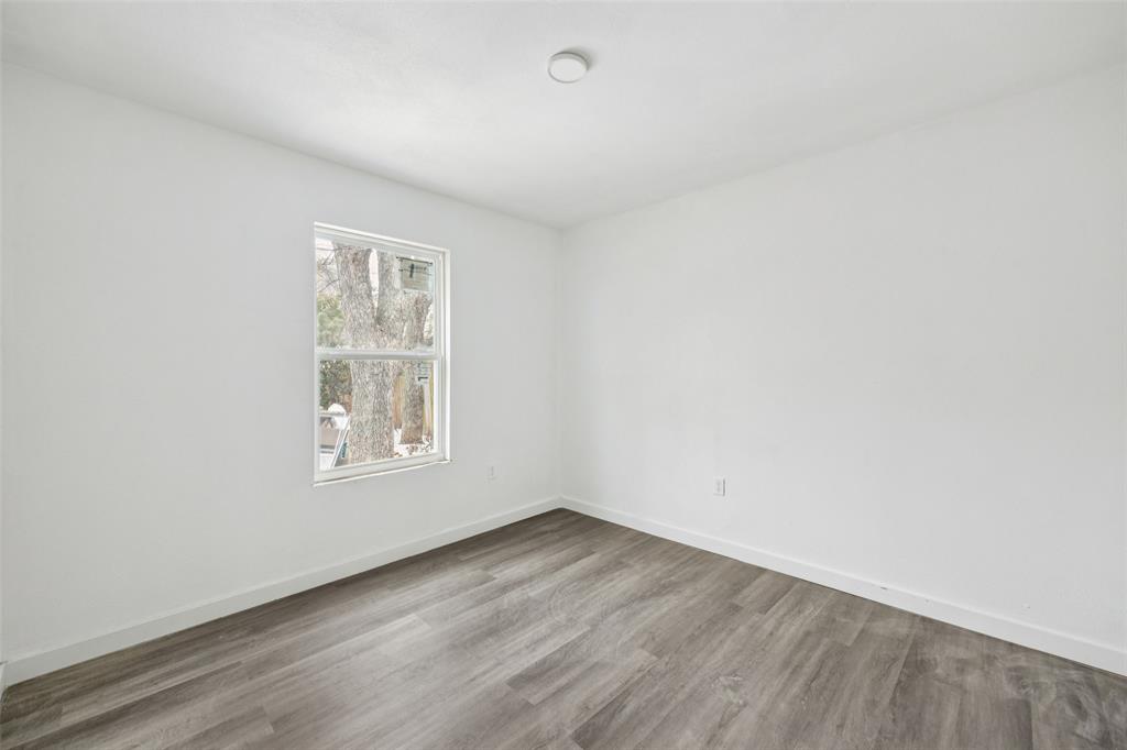 3847 Stalcup Road Fort Worth, TX 76119 - Photo 20 of 30 an empty room with wooden floor and windows
