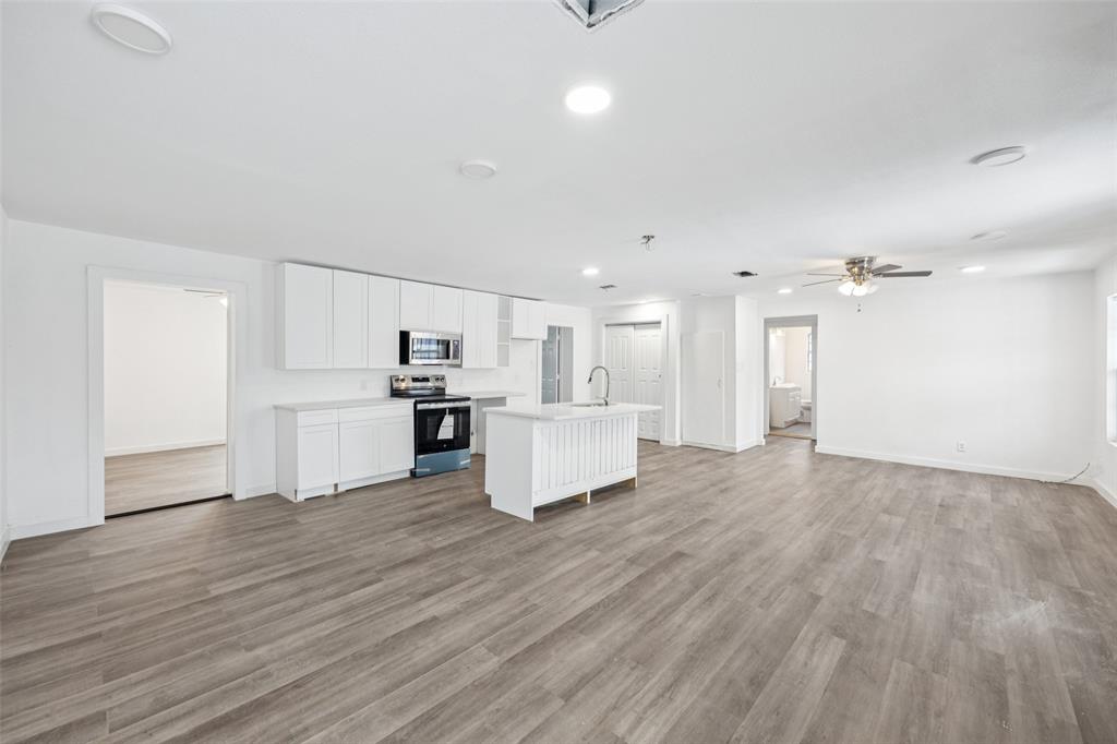 3847 Stalcup Road Fort Worth, TX 76119 - Photo 4 of 30 a view of kitchen with kitchen island wooden floors granite counter tops and white appliances