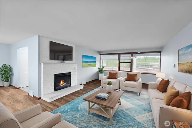 a living room with furniture a fireplace and a flat screen tv