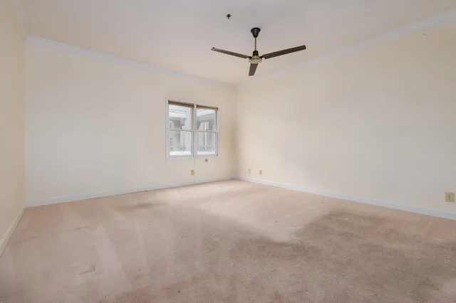an empty room with a window and a ceiling fan