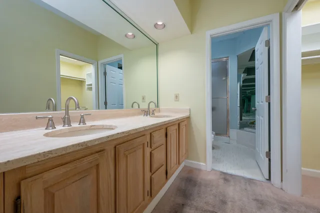 a bathroom with a double vanity sink mirror and next to a window