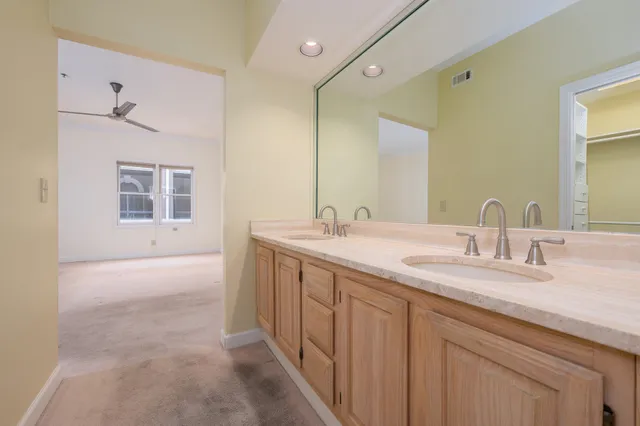 a bathroom with a double vanity sink a mirror and a bathtub