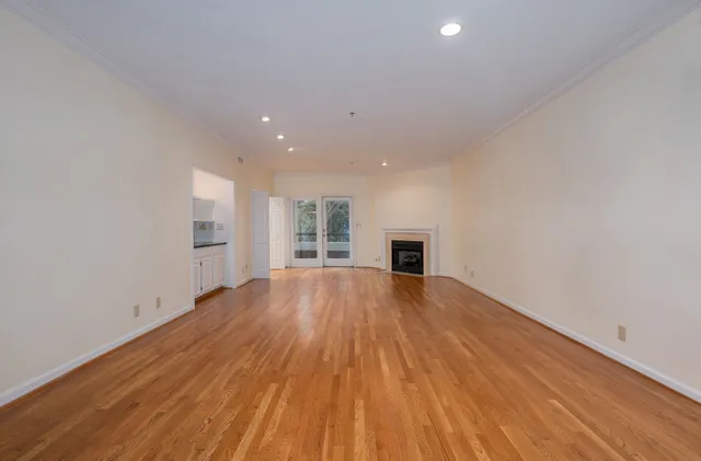 a view of empty room with wooden floor and fireplace