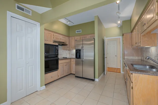 a kitchen with granite countertop a refrigerator and a sink