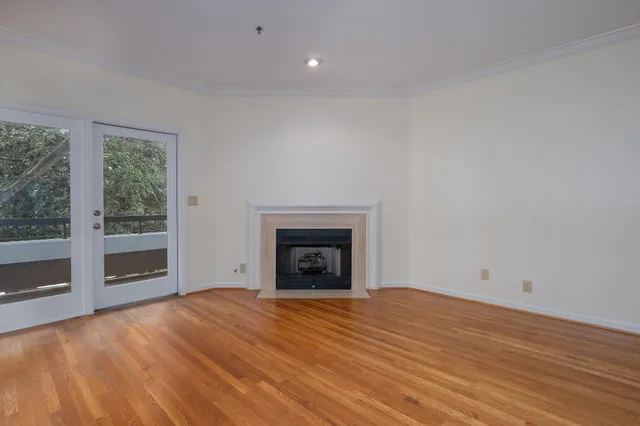 a view of empty room with wooden floor and fireplace