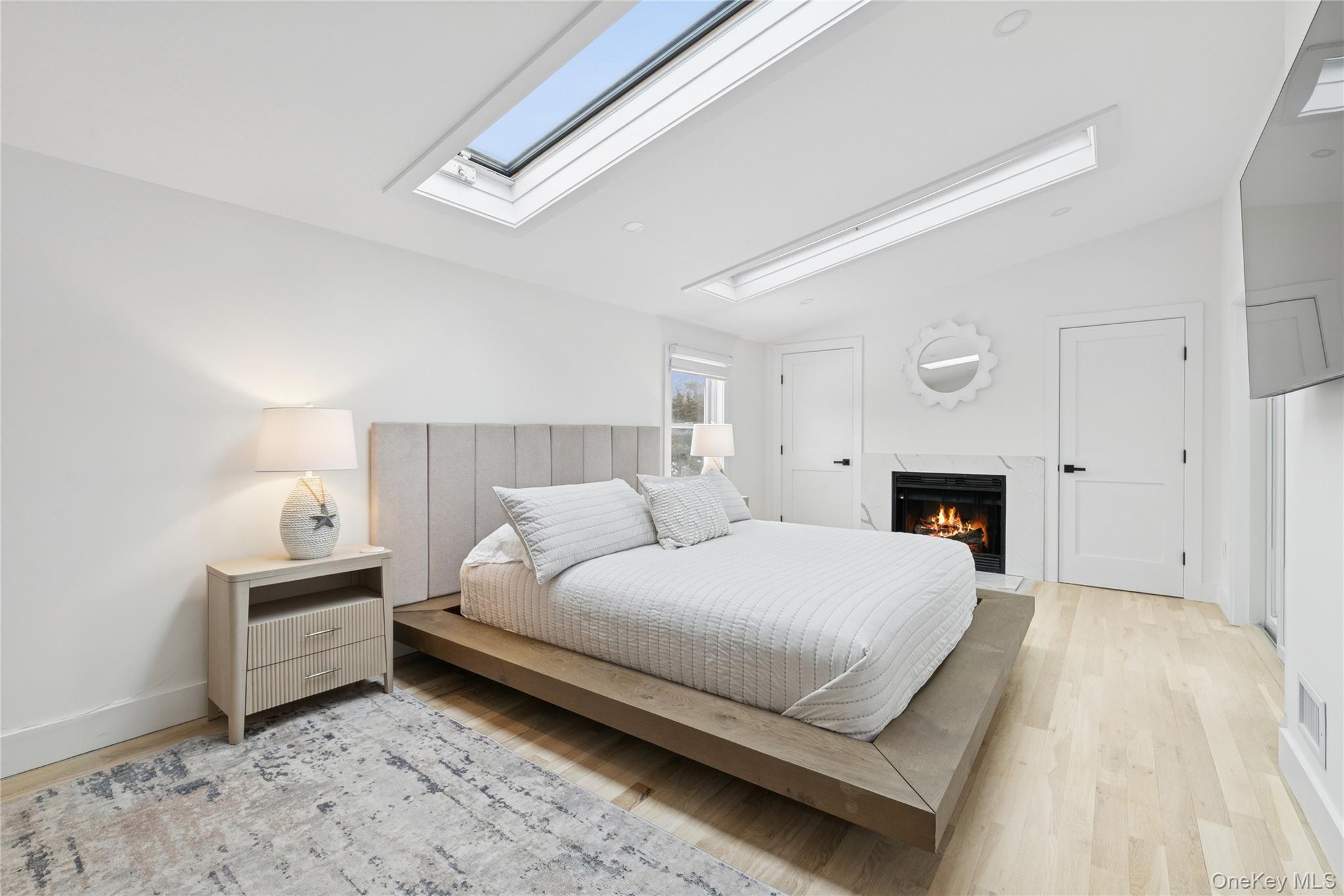 10 Sagamore Road Hampton Bays, NY 11946 - Photo 22 of 41 a bedroom with a bed and a fireplace
