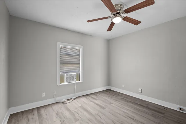 an empty room with a window and a fan
