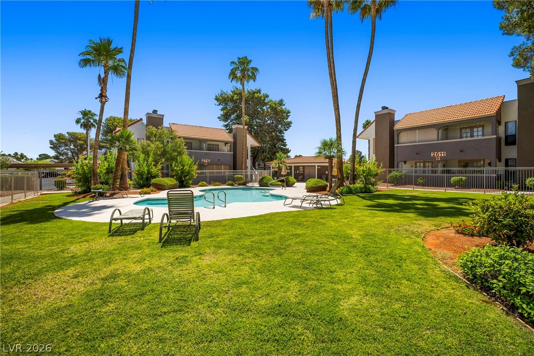 3311 Sunfish Drive, Unit D Henderson, NV 89014 - Photo 19 of 21 A refreshing pool nestled in a well-manicured green space, surrounded by inviting residences.