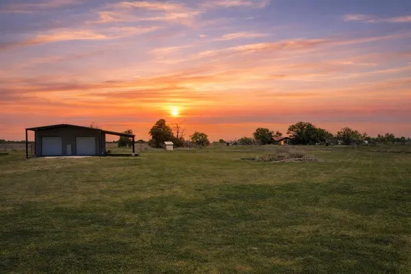 a view of a big yard with an ocean view