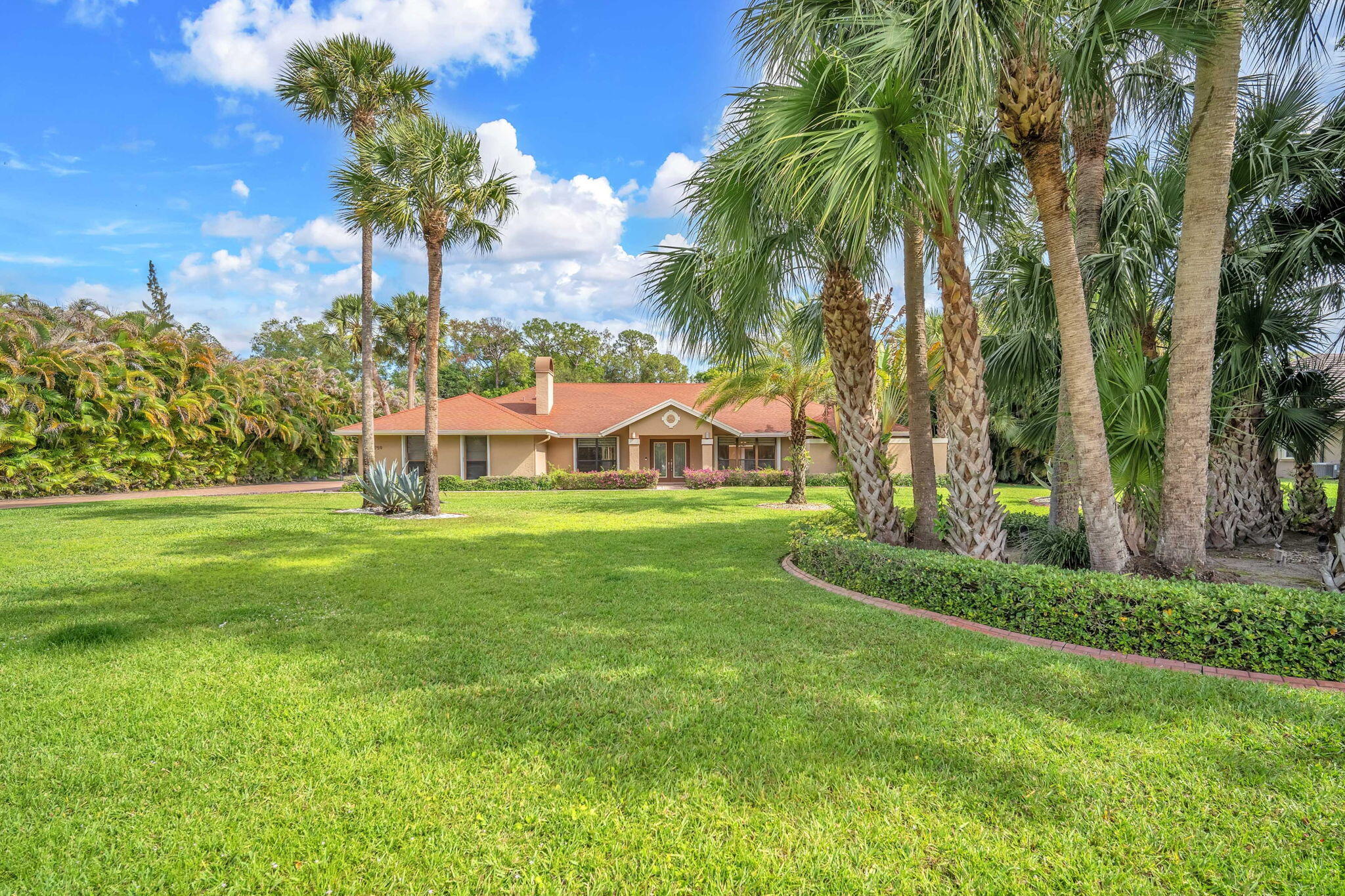 13759 Doubletree Trail Wellington, FL 33414 - Photo 4 of 76 a view of a house with a big yard and palm trees