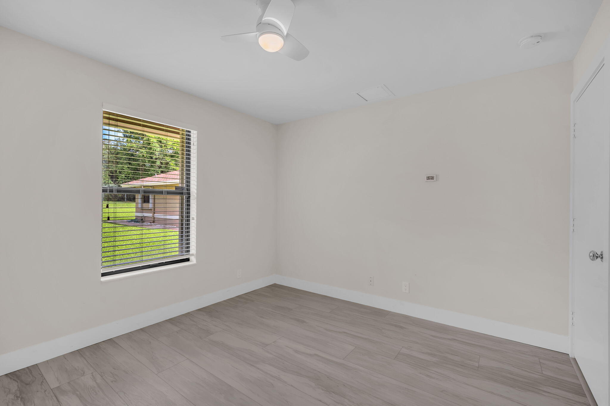 13759 Doubletree Trail Wellington, FL 33414 - Photo 48 of 76 an empty room with wooden floor and a window