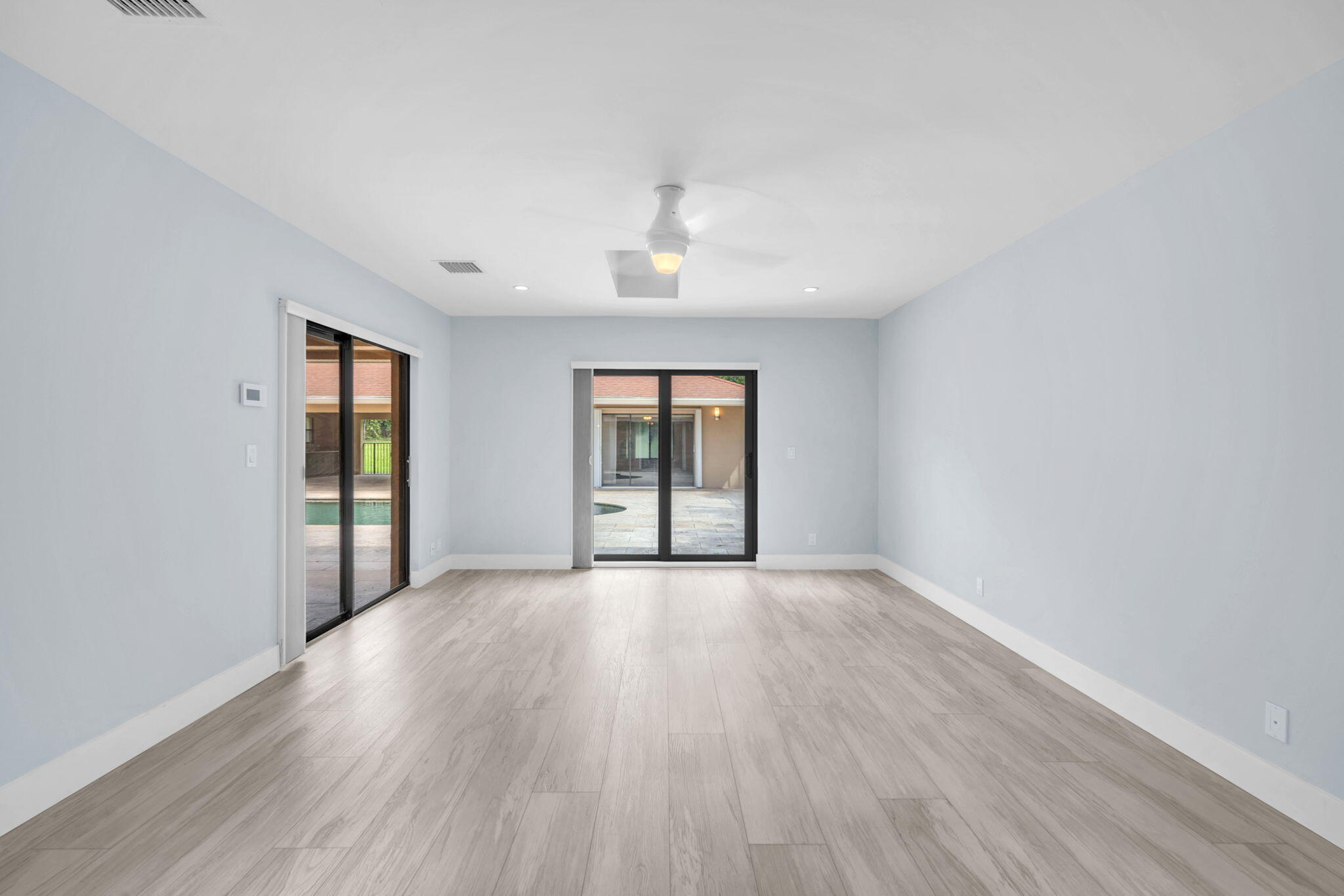 13759 Doubletree Trail Wellington, FL 33414 - Photo 53 of 76 an empty room with wooden floor chandelier and windows
