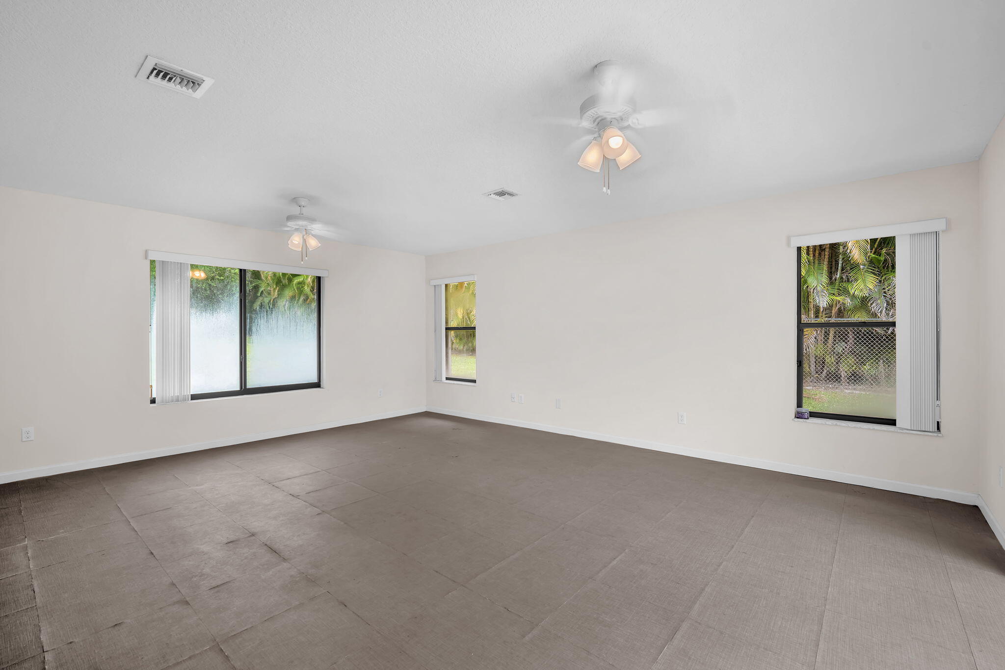 13759 Doubletree Trail Wellington, FL 33414 - Photo 71 of 76 an empty room with windows and chandelier fan