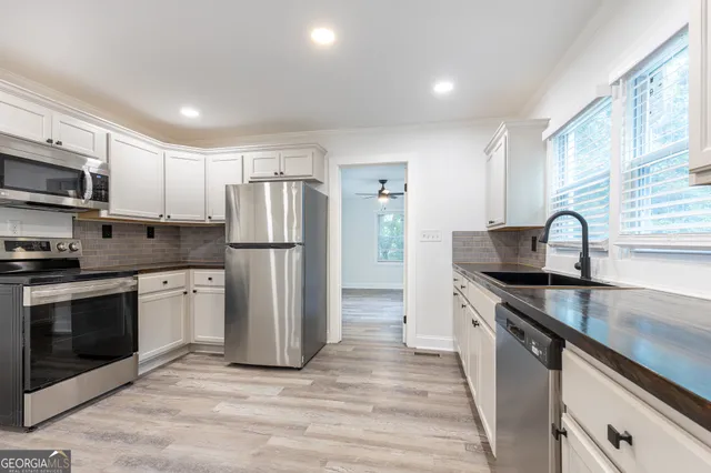 a kitchen with stainless steel appliances granite countertop a sink stove and refrigerator