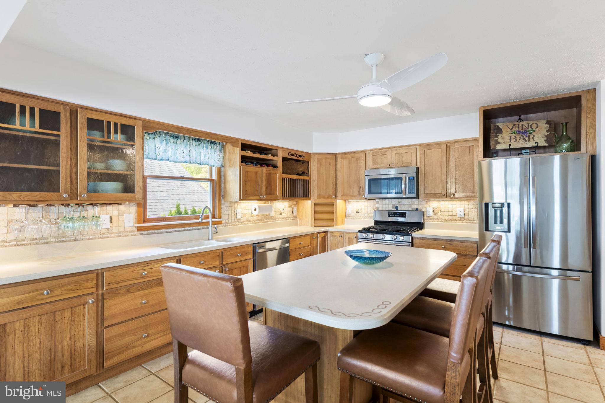 94 Crescent Lane Elkton, MD 21921 - Photo 8 of 59 a kitchen with stainless steel appliances granite countertop a dining table chairs refrigerator and sink