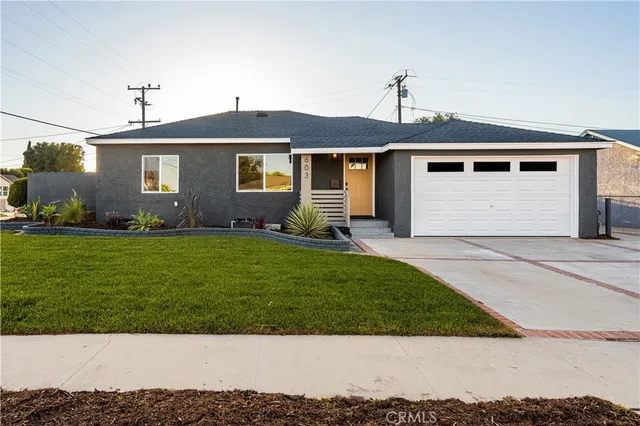 a front view of a house with a garden and yard