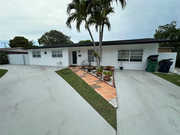 a front view of house with yard and trees in the background