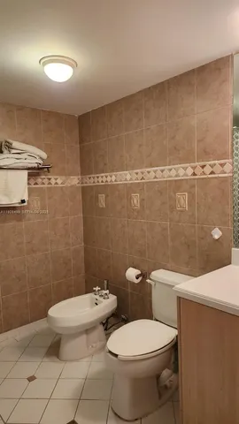 a white toilet sitting next to a bathroom sink