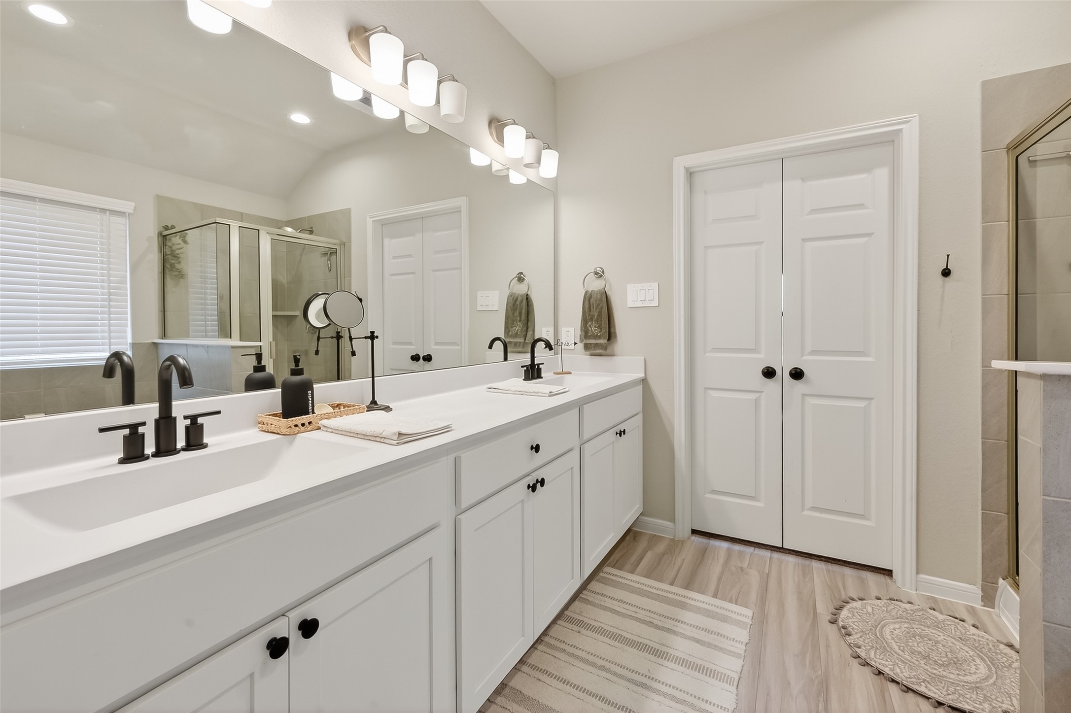 689 Red Elm Lane Conroe, TX 77304 - Photo 17 of 37 a bathroom with double vanity sinks a vanity a lamp and a mirror
