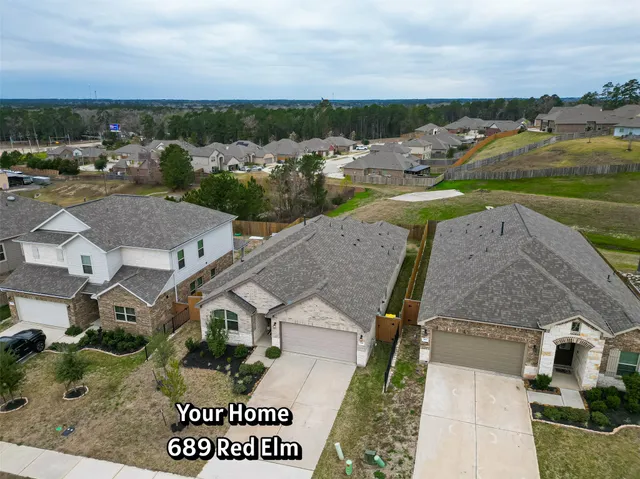 an aerial view of a house with garden space and ocean view