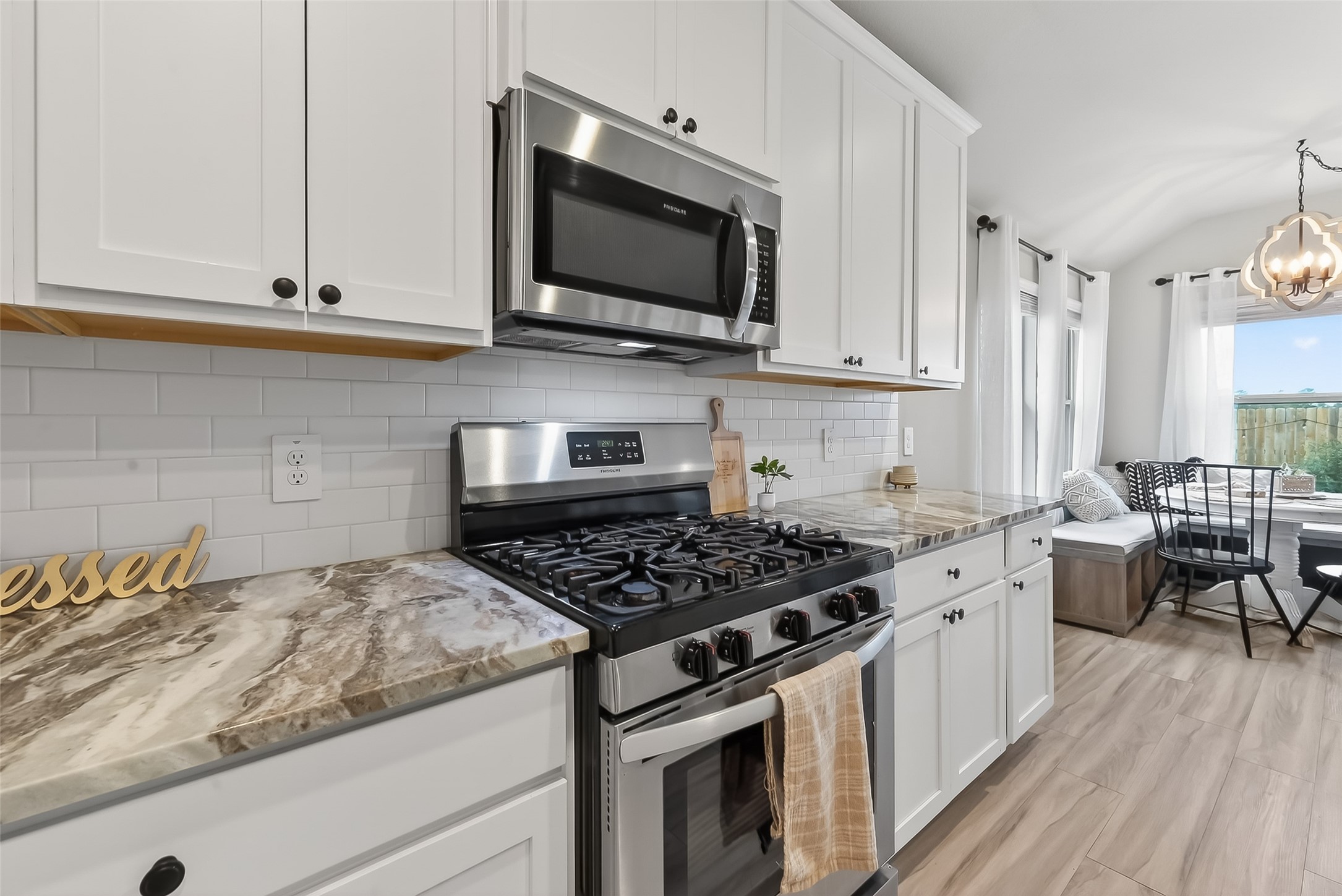 689 Red Elm Lane Conroe, TX 77304 - Photo 9 of 37 a kitchen with stainless steel appliances granite countertop a stove and a wooden floor