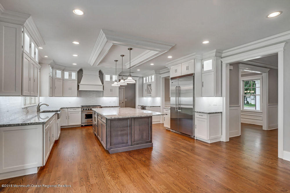 99 Rivers Edge Drive Little Silver, NJ 07739 - Photo 15 of 50 a large kitchen with stainless steel appliances kitchen island granite countertop wooden floors and a view of living room