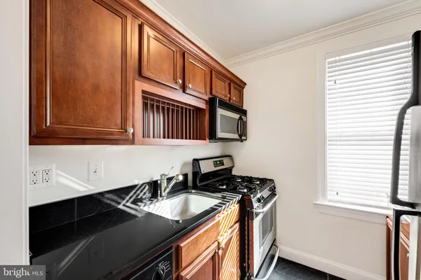 a kitchen with stainless steel appliances granite countertop a sink stove and cabinets