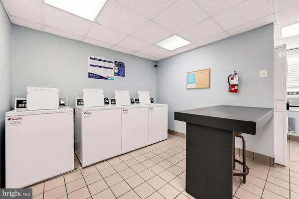 a view of kitchen with furniture and electronic appliances