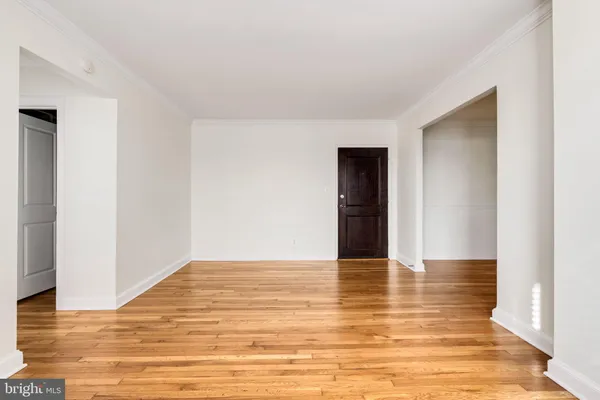 a view of an empty room with wooden floor