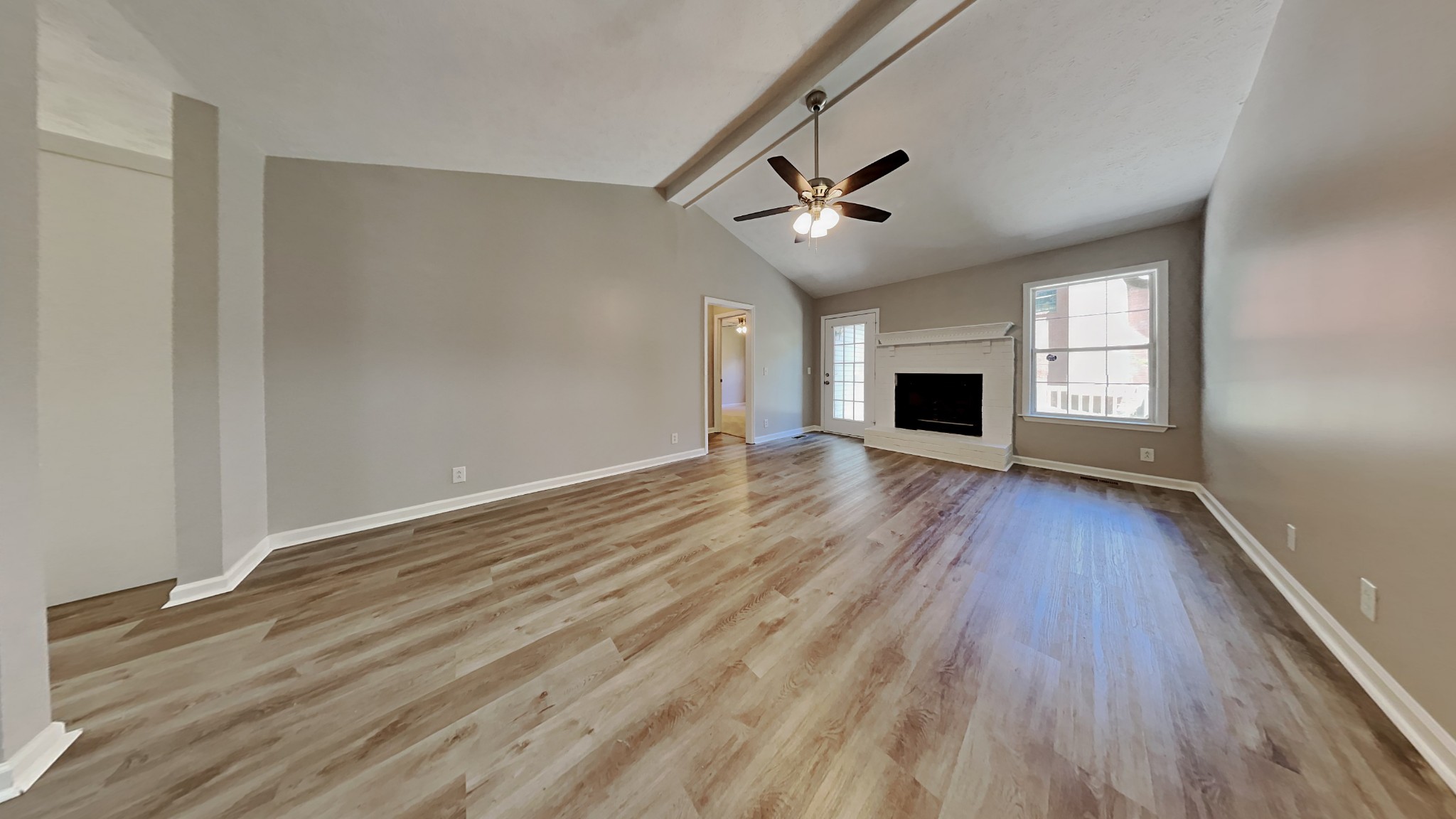 728 Bishopsgate Road Antioch, TN 37013 - Photo 2 of 15 an empty room with wooden floor fireplace and windows