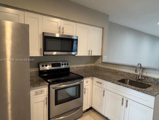 260 Southwest 8th Avenue, Unit B Hallandale Beach, FL 33009 - Photo 3 of 23 a kitchen with granite countertop white cabinets stainless steel appliances and a sink