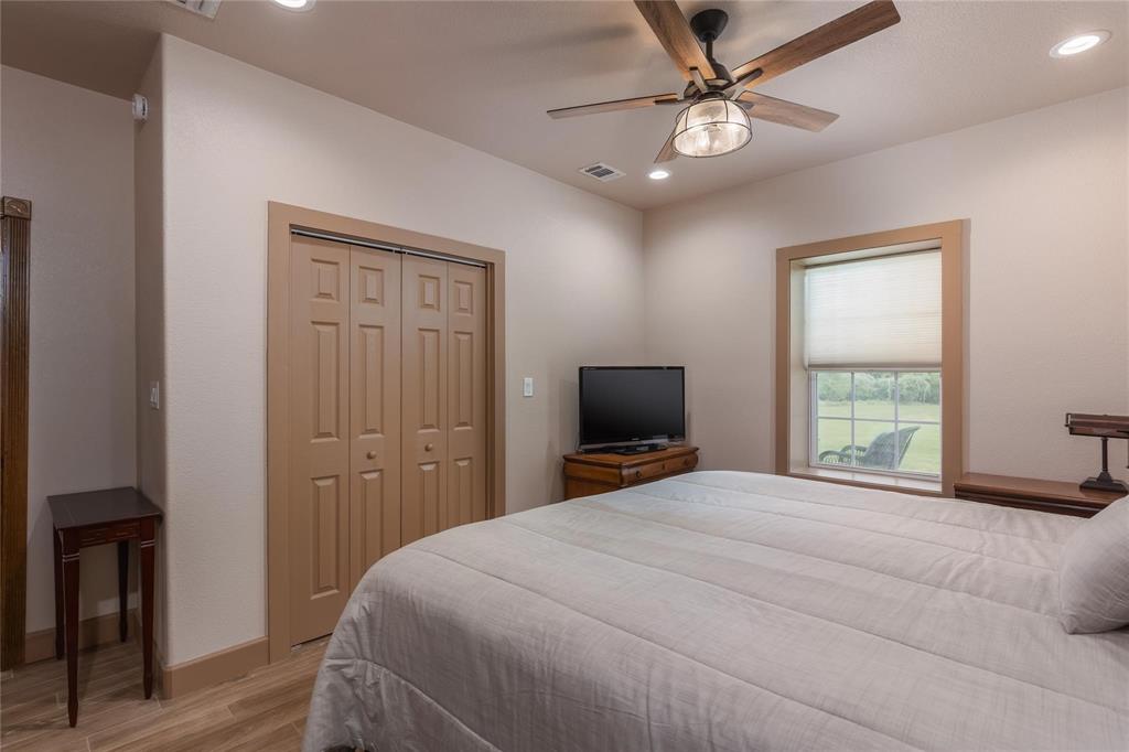 210 Spring Branch Trail North Springtown, TX 76082 - Photo 13 of 36 Bedroom featuring a ceiling fan with light fixture, recessed lighting, wood-finish flooring, a window with a roller shade, and bi-fold closet doors