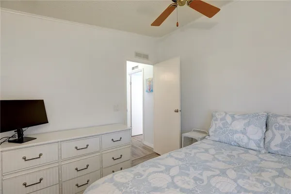 a bedroom with a bed and a flat tv screen on a dresser