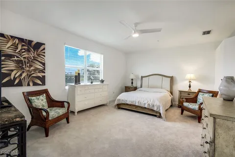 a spacious bedroom with a bed chair and window
