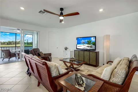 a living room with furniture a projector and a floor to ceiling window