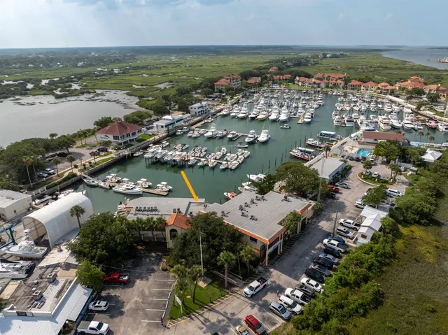 an aerial view of ocean and residential houses with outdoor space