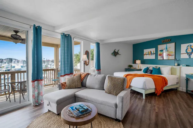 a living room with a bed and a couch next to a window