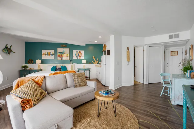 a living room with furniture and a wooden floor