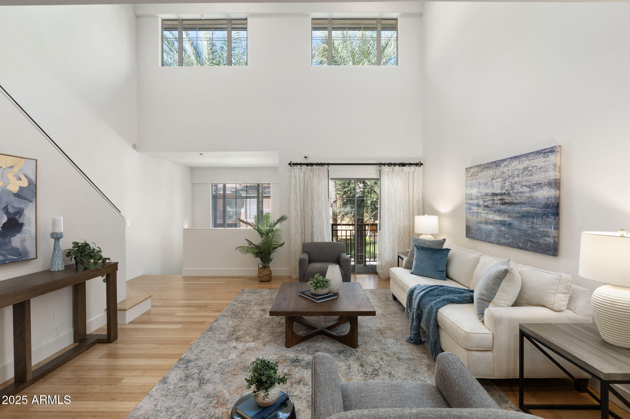 a living room with furniture wooden floor and a large window