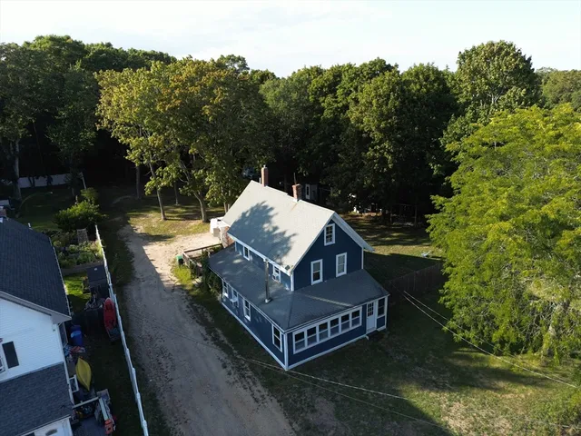 an aerial view of a house with balcony next to a yard