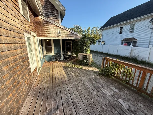 a view of a house with a barbeque and wooden stairs