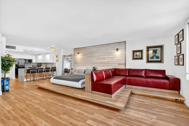 a living room with furniture and view of kitchen