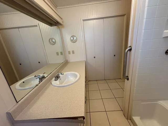 a bathroom with a granite countertop sink a mirror and shower