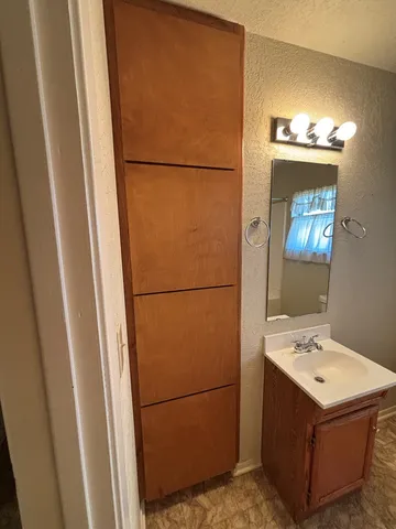 a bathroom with a sink and a refrigerator