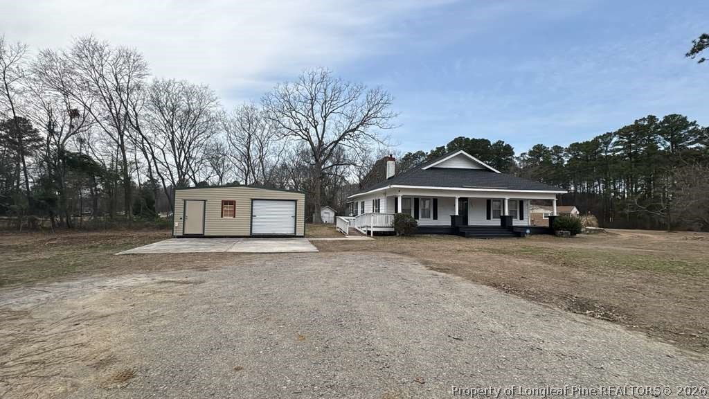 3174 Lindsay Road Raeford, NC 28376 - Photo 2 of 28 a front view of a house with a garden and trees