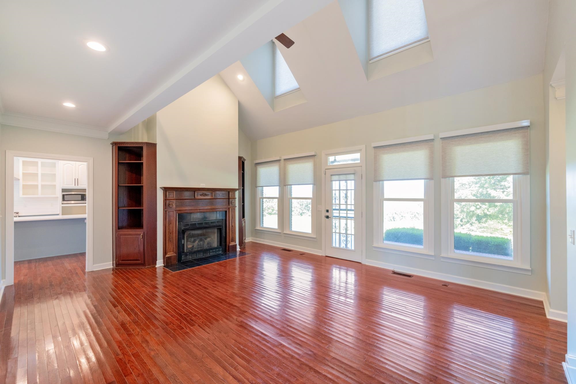 599 DT Vise Loop Parsons, TN 38363 - Photo 14 of 40 Unfurnished living room featuring healthy amount of natural light, dark wood-style floors, a fireplace with flush hearth, high vaulted ceiling, and recessed lighting