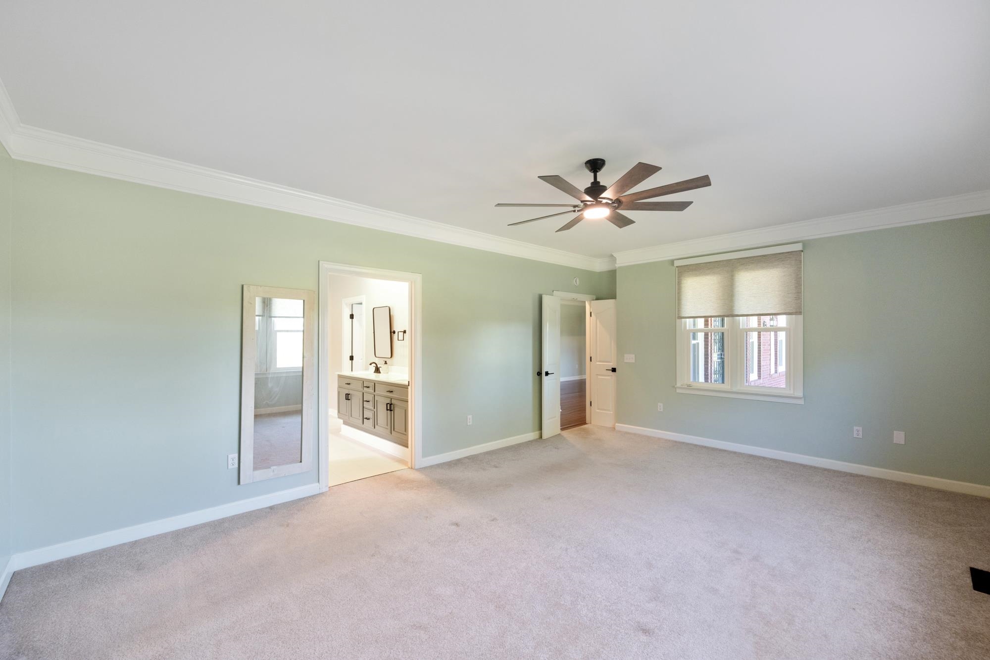 599 DT Vise Loop Parsons, TN 38363 - Photo 20 of 40 Unfurnished bedroom featuring ornamental molding, light carpet, connected bathroom, multiple windows, and ceiling fan
